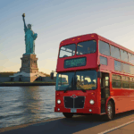 A golden-hour shot of a red double-decker Big Bus cruising past the Statue of Liberty, tourists smiling with cameras out, sun glinting off the water – ultra-realistic, travel magazine style.